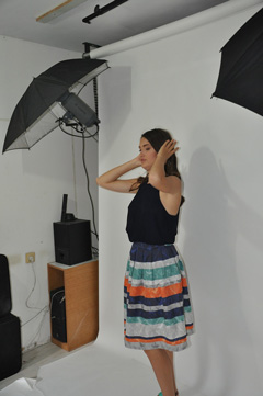 A model in the studio with backdrop and unbrella lamps