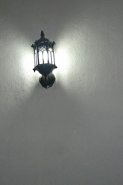the lamp is starkly defined by the emptiness of the wall behind it, the negative space
