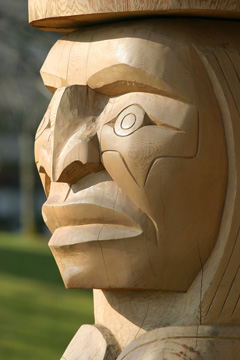 A carved, raw wood totem of the First Nations people