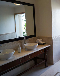 A framed mirror in the bathroom gives the room a sophisticated style